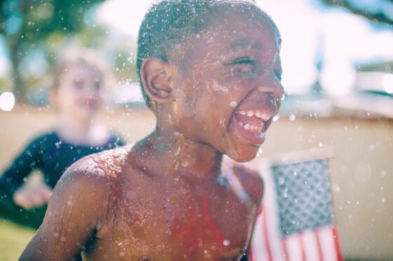 Exciting Staycation Ideas Families Need To Try Kids Playing in Sprinkler