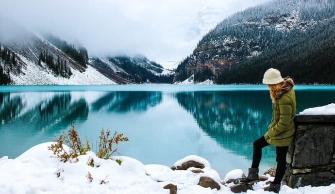 Cold Weather Gear To Take On a Vacation - woman hiking in winter