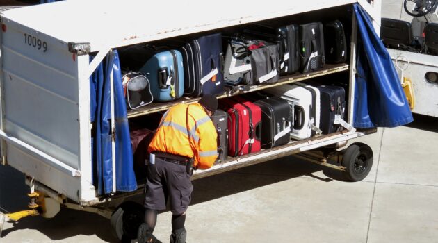 Best Travel essentials for 2024 - man adding luggage in airplane