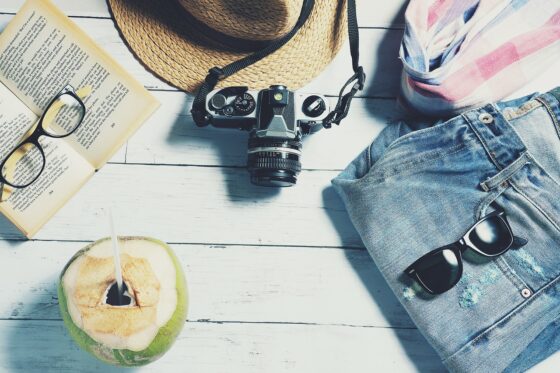 4 Simple Tips to Find Cheap Holiday Accommodations - camera book sunglasses