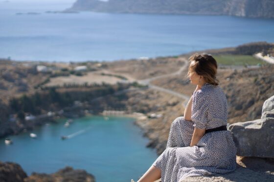 Tips to Make Your Vacation Less Stressful & More Enjoyable - woman by cliff