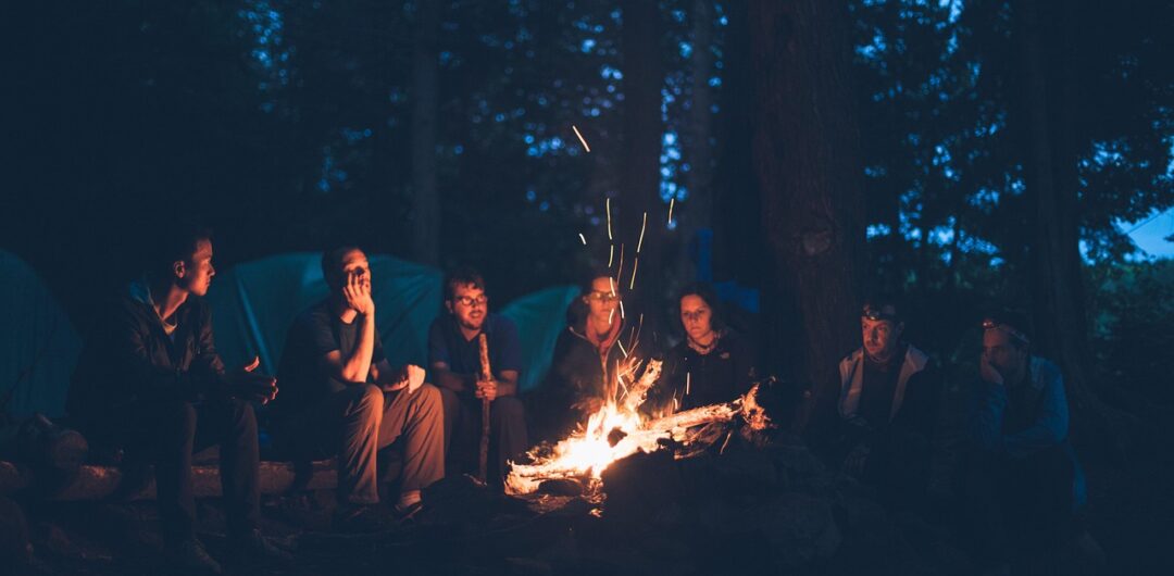 RV vs. Camping The Great Outdoors Debate - Group Around a Bonfire
