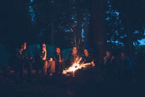 RV vs. Camping The Great Outdoors Debate - Group Around a Bonfire