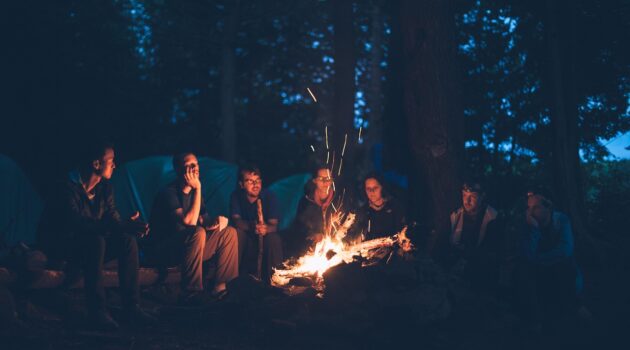 RV vs. Camping The Great Outdoors Debate - Group Around a Bonfire