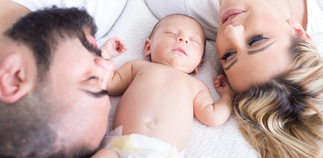 Helping Baby Sleep Longer - Baby Sleeping Between Mother and Father