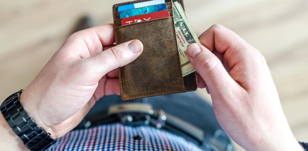 Understanding The Financial Faux Pas That Are Holding You Back 5 Understanding The Financial Faux Pas That Are Holding Your Back - Man Taking Money Out of a Wallet