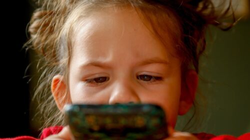 Online Card Games Five Benefits You Need to Know About - Child Playing on Phone
