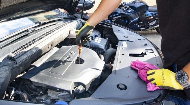 Beginners Guide To Car Fluids What You Need In Your Garage - Mechanic Changing Oil