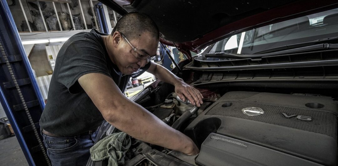 Beginners Guide To Car Fluids What You Need In Your Garage - Mechanic Working On Car