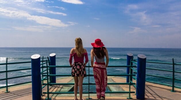 How Can You Plan Travel without Falling for Viral Tourist Traps - Two Women Standing on a Pier