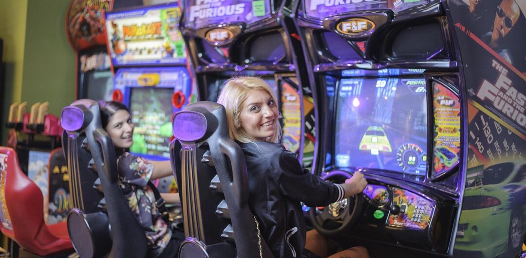 Why Arcades Make Every Trip More Fun and Memorable - Girls Playing Racing Arcade Games